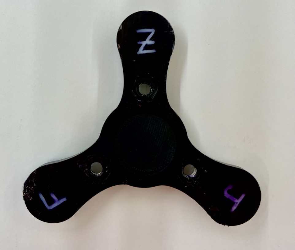Black HDPE fidget spinner with purple J, F, and Z initials on the three arms