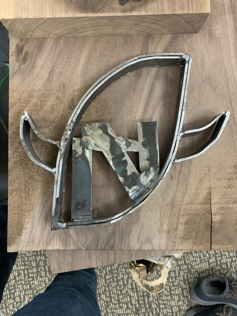 Finished welded metal N emblem trophy on a wooden workbench